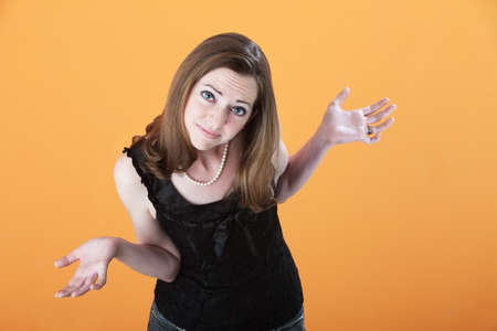 Young Caucasian woman on an orange background wonders why