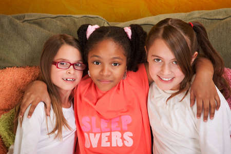 Three little friends hug each other on a couch 