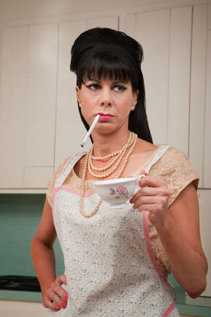 Tough housewife in apron with cigarette and coffee cup