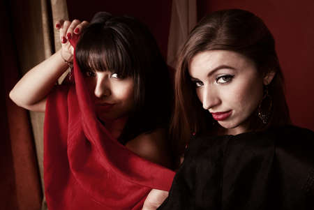 Two beautiful belly dancers hold scarves around themselvesの写真素材