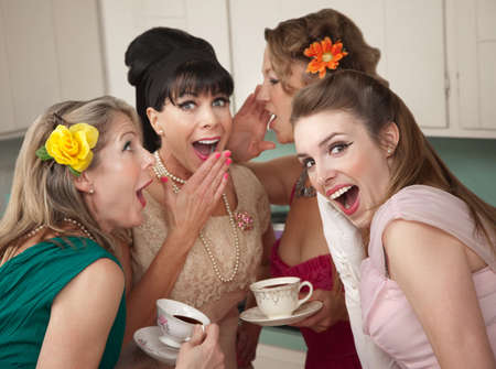 Group of four retro fashion housewives tell secrets in the kitchenの写真素材