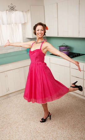 Middle aged Caucasian woman dances in a kitchenの写真素材