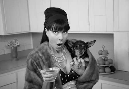 Retro styled Caucasian woman holding Chihuahua dog and martiniの写真素材