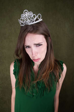 Cute young Caucasian woman with a crown tiara poutsの写真素材