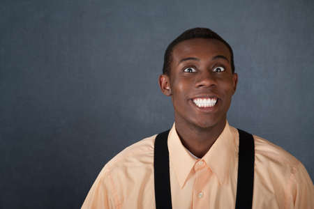 Happy young Black man on gray background with big grinの写真素材