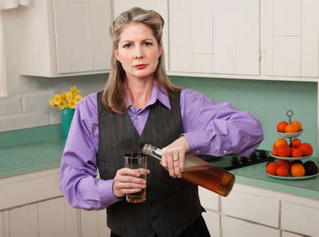 Woman in drag pouring alcohol into a glassの写真素材