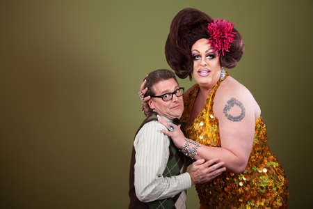 Large woman holding a uncomfortable nerd on green backgroundの写真素材