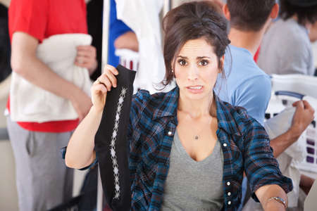 Disgusted woman holds one from a pair of socks