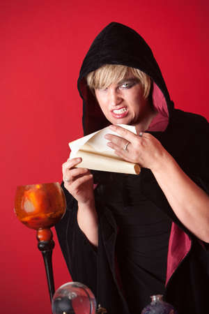 Evil witch reciting spells from a scrollの写真素材