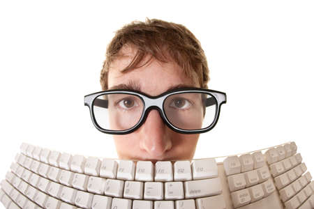 Young Caucasian man hides behind a computer keyboard over white backgroundの写真素材
