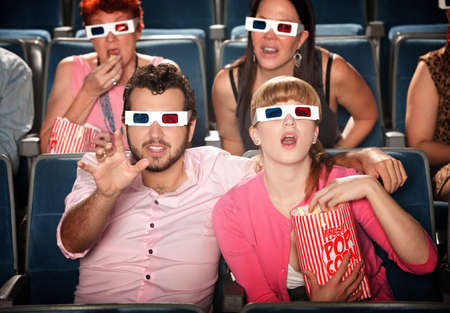 Amazed Caucasian couple with 3D glasses in theater seatsの写真素材