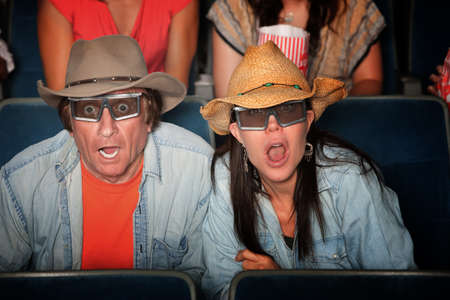 Shocked Caucasian couple with hats and 3D glassesの写真素材