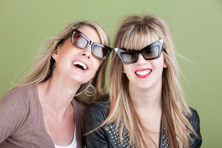 Happy Caucasian mom and daughter in sunglasses laugh over a jokeの写真素材