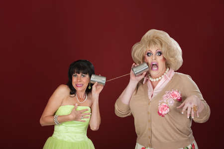 Retro-styled woman with drag queen talk through tin can phonesの写真素材