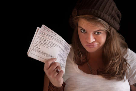 Unhappy woman with welfare food coupons over dark backgroundの写真素材