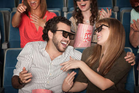 Couple with 3D glasses in theater laughing together