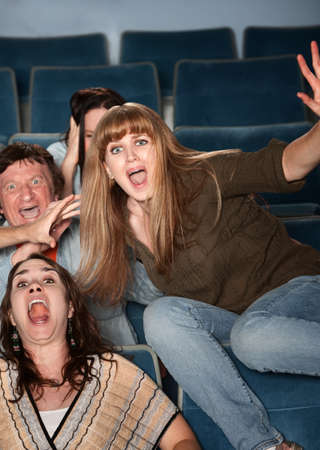 Scared Caucasian teen jumps out of her seat in theaterの写真素材