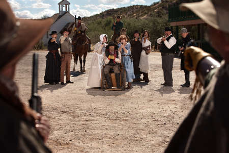 Townspeople under attack from bandits in old west scene