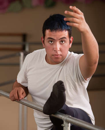 Young male ballet dancer with leg on railingの写真素材