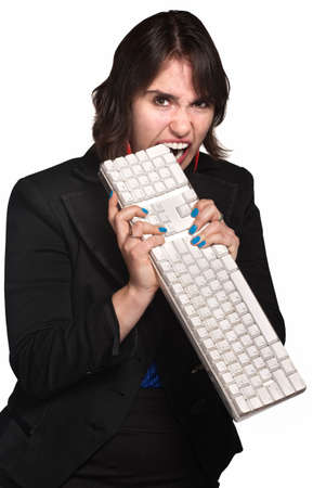 Aggressive businesswoman chewing keyboard over white backgroundの写真素材