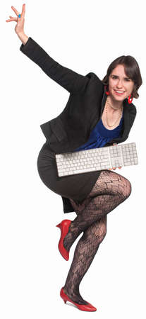 Businesswoman playing air guitar with computer keyboardの写真素材