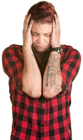 Young man in flannel grabbing the sides of his head