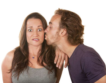 Surprised woman being kissed by bearded white man