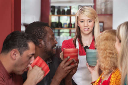 Diverse group of customers with mugs and restaurant attendant