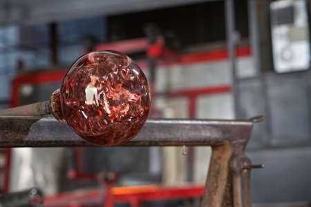 Finished fine art glass vase cooling on iron tableの写真素材