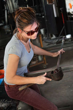 Female glass manufacturing business artist working with tools