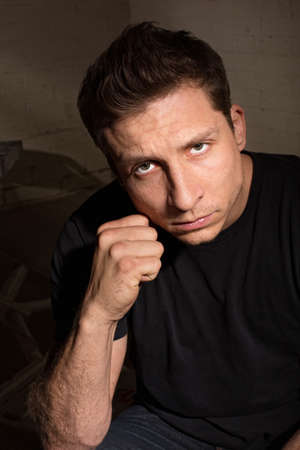 Tense young white man with clenched fist indoors