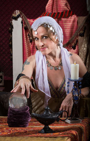 Exotic Romani woman with candle and crystal ballの写真素材
