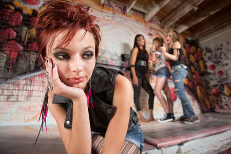 Bored teen with chin in hands near groupの写真素材