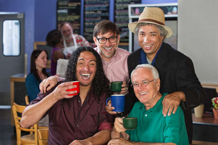 Diverse group of men celebrating in coffee houseの写真素材