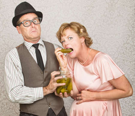 Craving pregnant woman eating pickles from a jarの写真素材