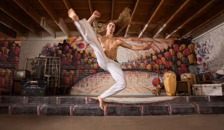 Handsome capoeira performers demonstrating a flying kickの写真素材