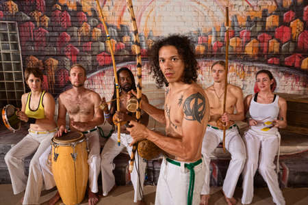 Handsome Latino Capoeira expert with musical instrumentsの写真素材