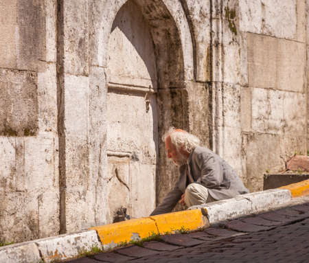 ISTANBUL, TURKEY â APRIL 28: Galata neighborhood man in Istanbul filling a water bottle at a public faucet on April 28, 2012 in Istanbul, Turkey prior to Anzac Day.  のeditorial素材