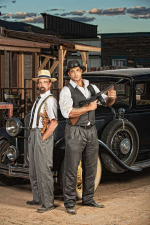 1920s era criminal partners with guns outdoorsの写真素材