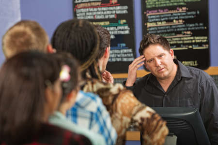 Confused barista at cash register in cafe