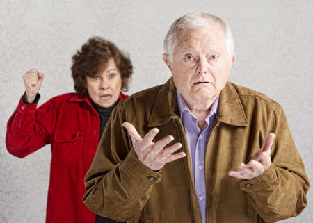 Confused elderly man with angry older womanの写真素材