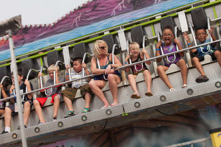 DES MOINES, IA /USA - AUGUST 10: Unidentified people enjoy a carnival thrill ride at the Iowa State Fair on August 10, 2014 in Des Moines, Iowa, USA.のeditorial素材