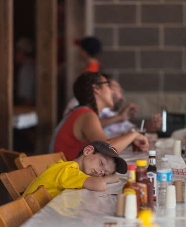DES MOINES, IA /USA - AUGUST 10: Unidentified tired boy rests head on table at the Iowa State Fair...