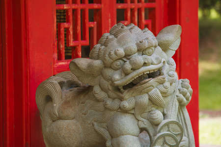 Chinese Guardian Lion in Front of Red Structureの写真素材