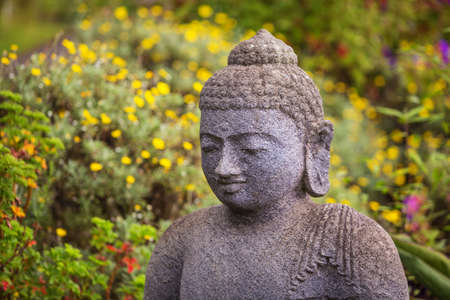 Close up of grinning stone Buddah statueの写真素材