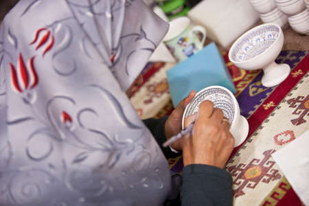 CAPPADOCIA, TURKEY â APRIL 17: Woman decorates a ceramic bowl with designs typical to the region on April 17, 2012 in Cappadocia, Turkey.のeditorial素材