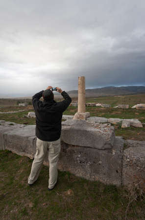 American tourist taking a photo of Ionic column at Antioch Pisidian in Turkeyの写真素材