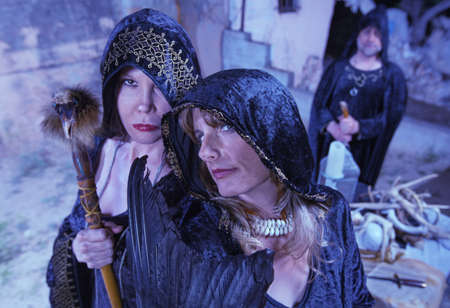Group of witches in black robes near altar outdoorsの写真素材