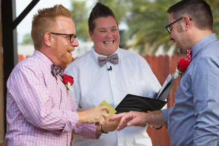 Gay couple in wedding ring ceremony with ministerの写真素材
