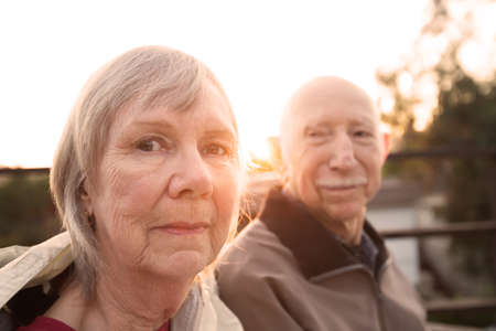 Calm Caucasian senior couple sitting together outdoorsの写真素材